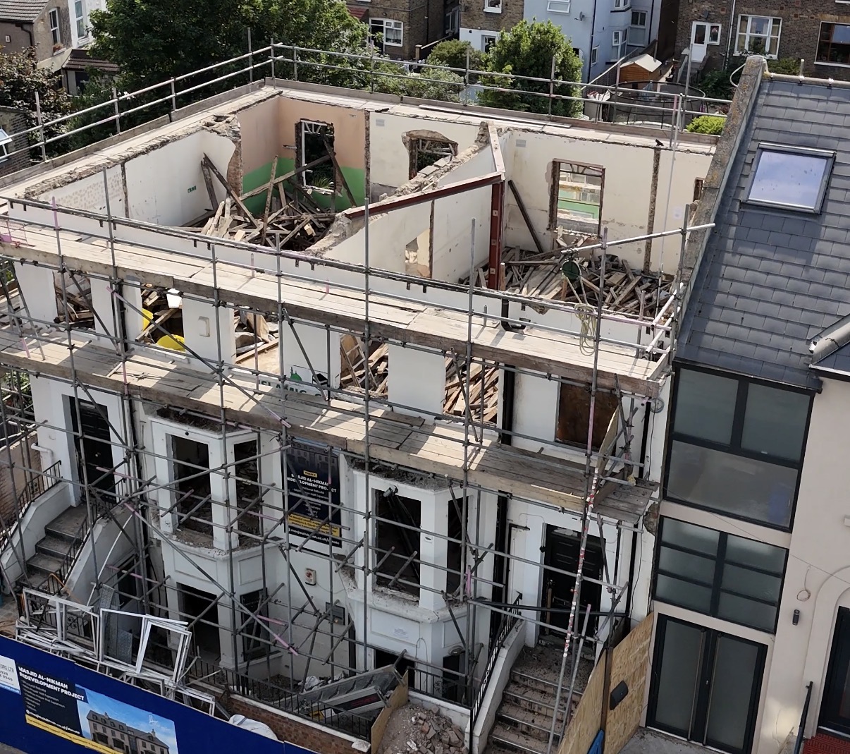 Deconstruction — upper floors removed with the front facade retained, May 2026